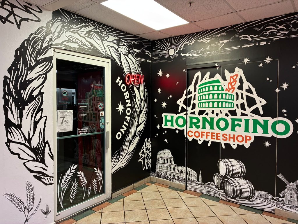 La entrada de HORNOFINO Cupey, con el mural del Coliseo y los barriles pintado alrededor del rótulo