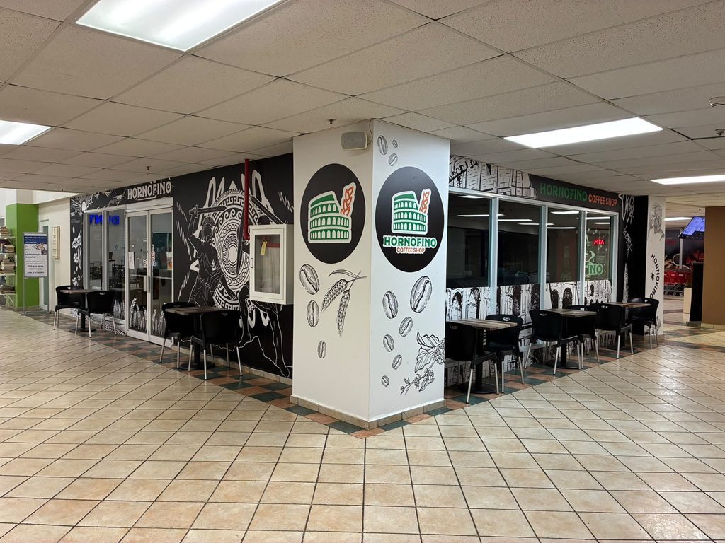 La columna del local con el logo del Coliseo y los granos pintados, vista desde el pasillo del centro comercial