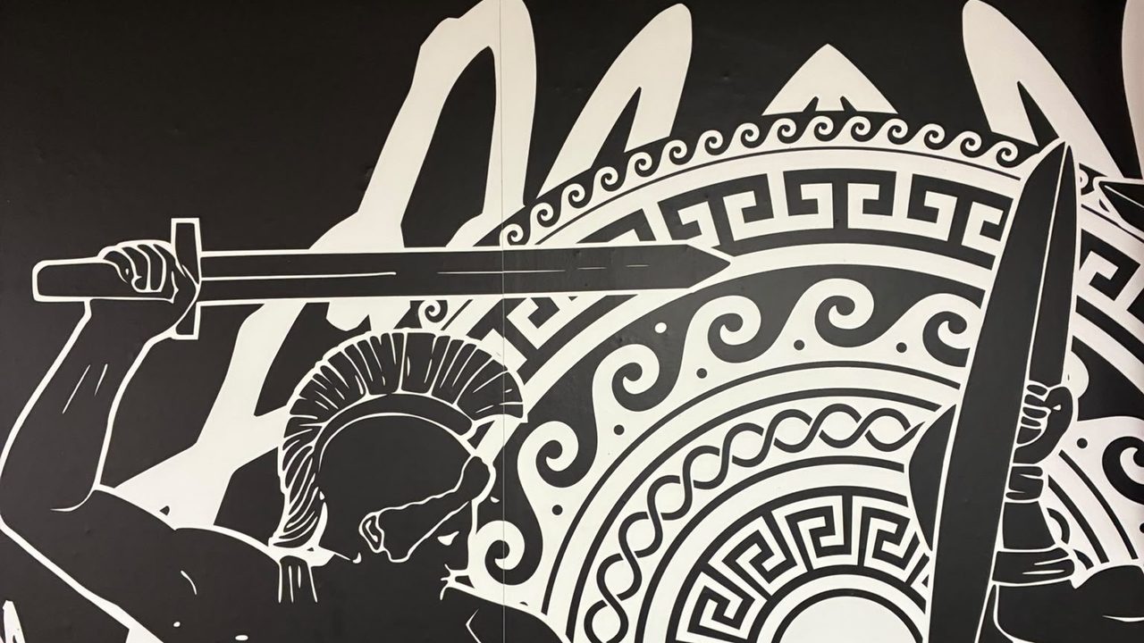 Mural pintado en la panadería: un guerrero griego con espada y escudo, en blanco y negro