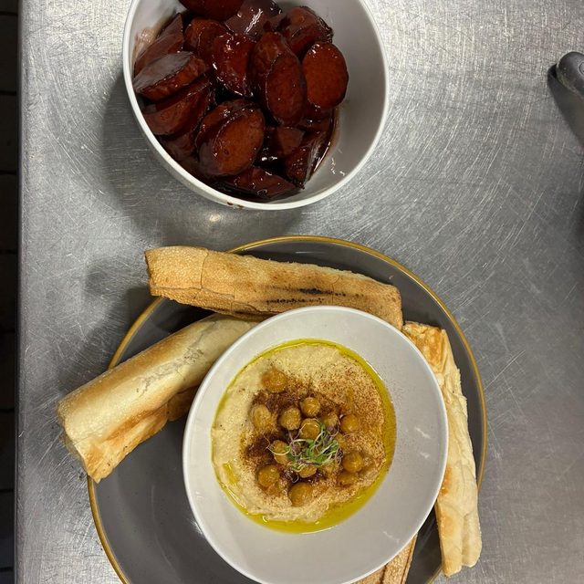 Mofongo relleno con guiso, servido con tostones en un plato de la casa