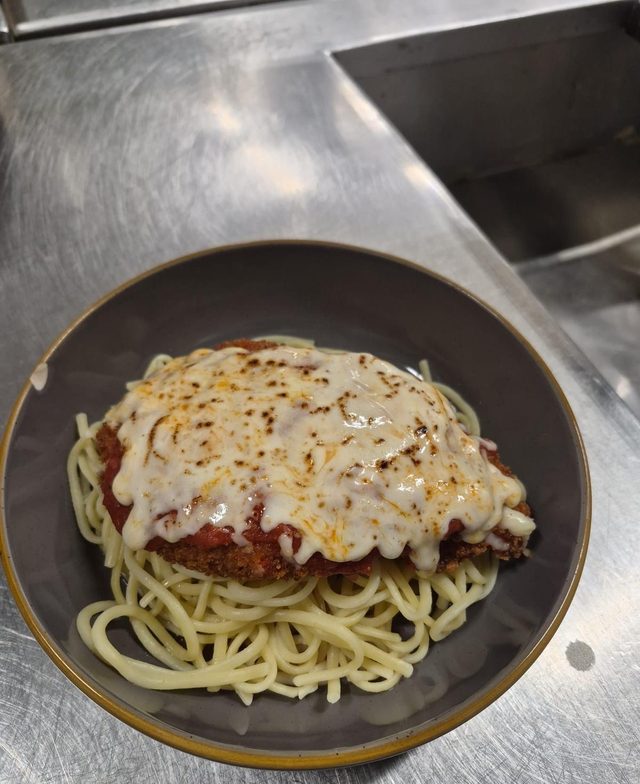 Pollo a la parmesana sobre spaghetti
